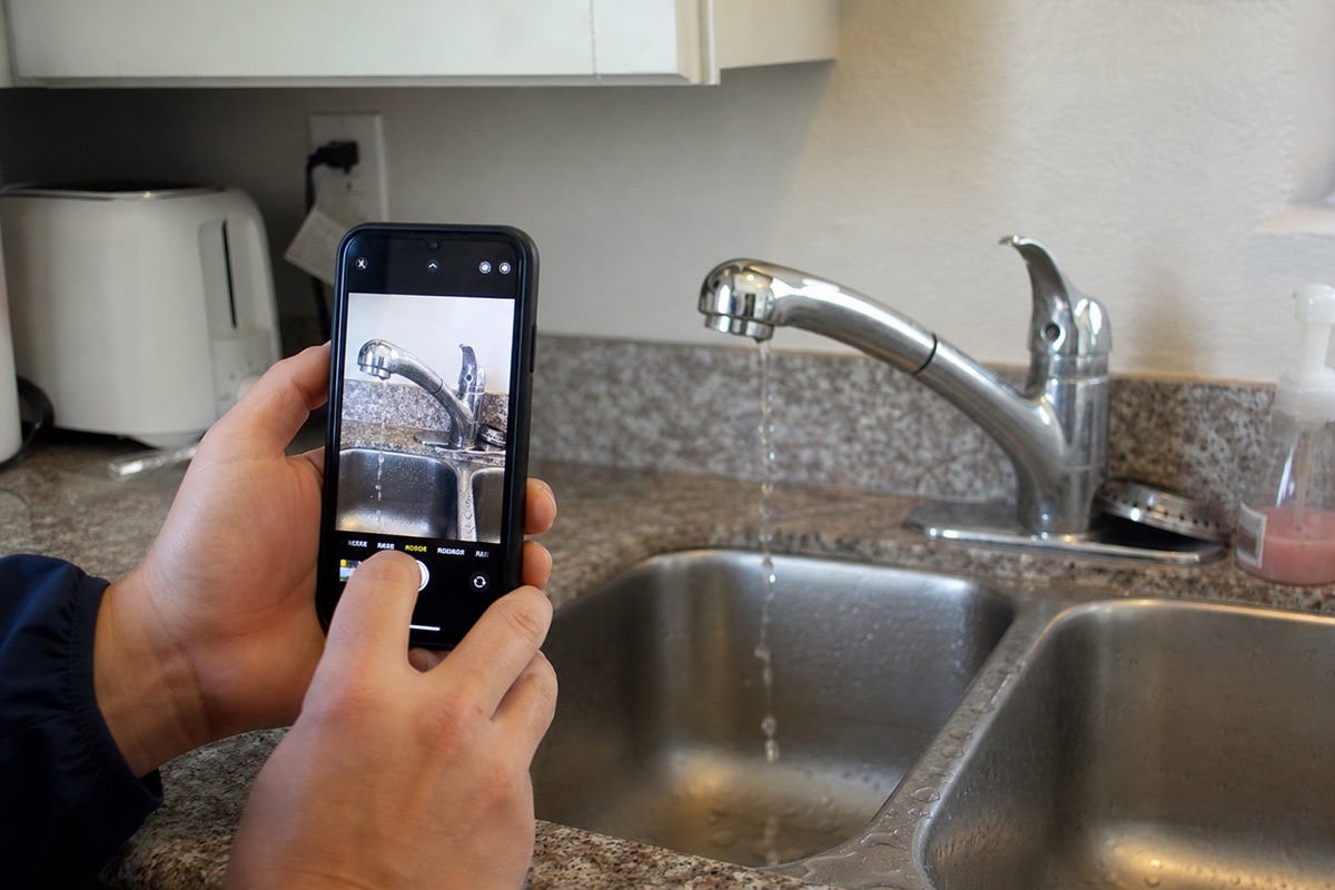 A tenant reporting a leak by photographing it from their phone